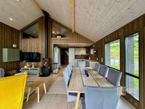 a dining room with a long wooden table and chairs at Modern cabin Skeikampen with ski-in out cross country trails & great view in Aulstad