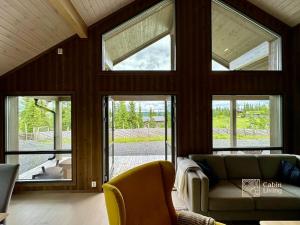 a living room with large windows and a couch at Modern cabin Skeikampen with ski-in out cross country trails & great view in Aulstad