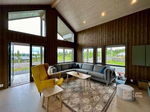a living room with a couch and a table at Modern cabin Skeikampen with ski-in out cross country trails & great view in Aulstad +33 photos