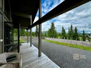 a wooden porch of a house with a fence at Modern cabin Skeikampen with ski-in out cross country trails & great view in Aulstad