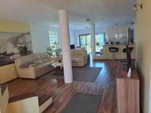 a living room with two couches and a kitchen at Casa Anna in Tîrnăveni