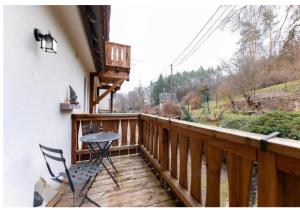 a wooden balcony with a table and chairs on it at Le refuge de la Vallée - pleine nature - 4 guests in Barr