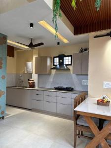 a kitchen with white cabinets and a table in it at The Sparrows Nest Villa in Bhīm Tāl