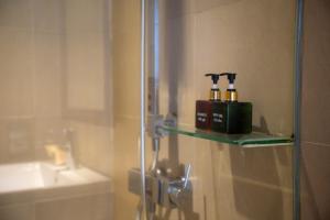 a bathroom with a glass shelf with two bottles on it at Premium Apartment, Balcony Ocean View,Infinity Pool, 01 Min To My Khe Beach, PickUp Managed by Ala Carte Da Nang in Da Nang +108 photos