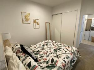 una camera da letto con un letto con una coperta a fiori di Sunset Apartment, Mount views, POOL, GYM, HOT TUB a Mount Maunganui Altre 14 foto