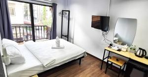 清迈GO INN Chiang Mai University - CMU的卧室里有一张床、一面镜子和一台电视