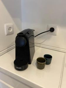 a toaster sitting on a shelf with two cups at A Minha Casinha in Almada