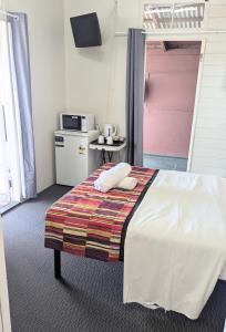 Postel nebo postele na pokoji v ubytování GRAND CENTRAL HOTEL PROSERPINE
