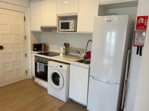 a kitchen with a refrigerator and a washing machine at A Minha Casinha in Almada