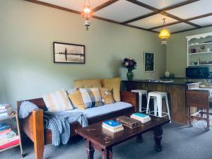 a living room with a couch and a table at Matakana Waterfall Hideaway in Warkworth