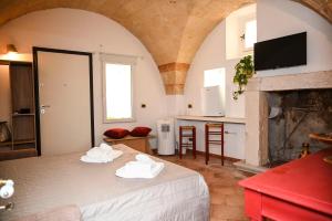 Una sala de estar con una cama y una cocina. en Il Voltone - Vivi Salento, en Copertino