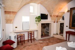 Una sala de estar con chimenea y televisión. en Il Voltone - Vivi Salento, en Copertino 22 fotos más
