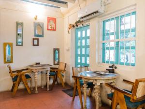 a room with two tables and chairs and a window at Moustache Daman in Daman