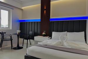 una camera da letto con un letto, un tavolo e delle sedie di Central Block Inn a Bacolod