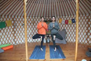 two people doing yoga in a yurt at Ecologic glamping in Estevais