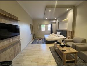 a living room with a bed and a couch at فندق وفود فرع رفحاء in Rafha