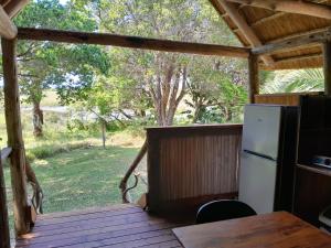 a porch with a refrigerator and a table on a deck at Kosi Bay Casitas in Manguzi