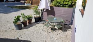 a table with chairs and an umbrella and some plants at Les orangers in Ravilloles