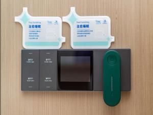 a microwave with a green remote control next to it at Lavande Hotel Credit Building of Gaocheng District, Shijiazhuang City in Dongliucun