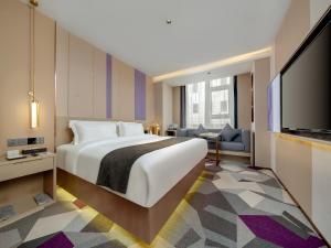 a bedroom with a large bed and a flat screen tv at Lavande Hotel Credit Building of Gaocheng District, Shijiazhuang City in Dongliucun