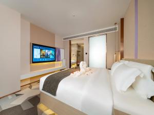 a bedroom with a large white bed with a flat screen tv at Lavande Hotel Credit Building of Gaocheng District, Shijiazhuang City in Dongliucun