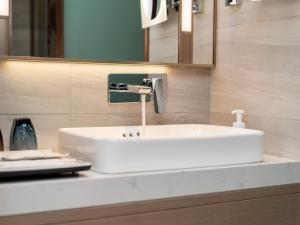 a white sink in a bathroom with a mirror at Lavande Hotel Credit Building of Gaocheng District, Shijiazhuang City in Dongliucun