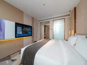 a bedroom with a large bed and a flat screen tv at Lavande Hotel Credit Building of Gaocheng District, Shijiazhuang City in Dongliucun