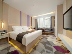 a hotel room with a large bed and a flat screen tv at Lavande Hotel Credit Building of Gaocheng District, Shijiazhuang City in Dongliucun