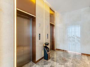 a elevator lobby with a metal door and a trashcan at Lavande Hotel Credit Building of Gaocheng District, Shijiazhuang City in Dongliucun