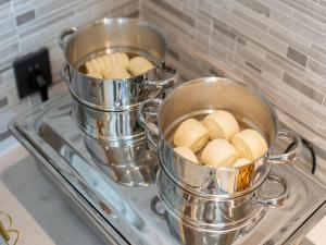 two pans sitting on a stove with food in them at Lavande Hotel Credit Building of Gaocheng District, Shijiazhuang City in Dongliucun