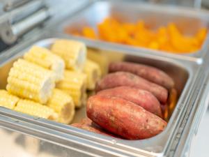 a tray of food with sausage corn and other foods at Lavande Hotel Credit Building of Gaocheng District, Shijiazhuang City in Dongliucun