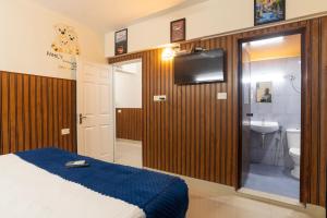 a bedroom with a bed and a bathroom with a sink at Sancta Maria Airport Hotel in Cochin
