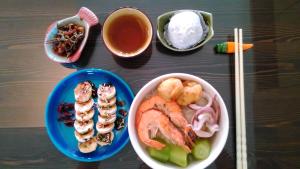 uma mesa coberta com pratos de comida e uma tigela de sushi em Rainbow Sea Bed and Breakfast em Huxi