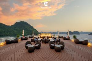 a deck with a table and chairs on a boat at Catherine Cruise in Ha Long