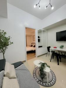 una sala de estar con un sofá y una mesa en Park Mckinley West 1BR Balcony near BGC Makati Airport, en Manila