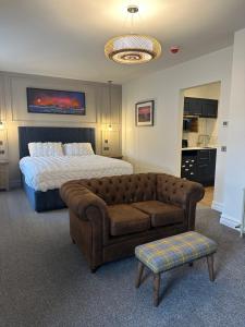 a bedroom with a bed and a couch and a bed and a table at Somerled House Suites in Portree