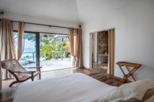 a bedroom with a bed and a sliding glass door at Tamarin Paradise Bay Villa 3 chambres sur la plage in Tamarin +99 photos