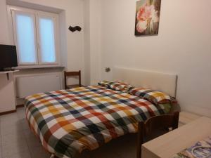 a bedroom with a bed and a table and a window at Foresteria Lombarda da Giovanna in Barzio