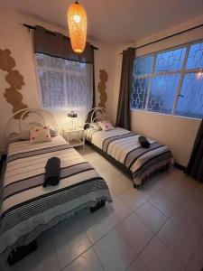 two beds in a room with a window at Appartement Baobab 2 in Pereybere