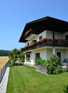 a white house with a balcony and flowers at Haus Gruber in Attersee am Attersee
