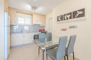 a kitchen with a glass table and chairs at Trebol House, Edificio Cañadas, Golf del Sur in San Miguel de Abona