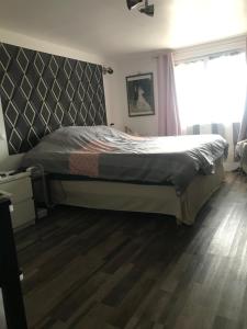 une chambre avec un grand lit avec une tête de lit dans l'établissement Les pieds dans l'eau, à Valras-Plage