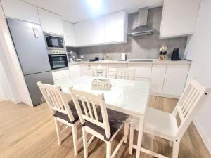 a white kitchen with a dining table and chairs at Vivienda El Viajero in Valverde