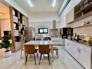 a kitchen with a table and chairs in it at Guangmei's home 台東縣民宿第2101號 in Chenggong