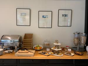 a counter with bread and other food items on it at Les Criquets Hôtel & Spa in Blanquefort