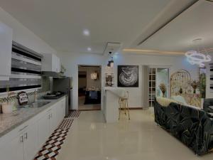 une cuisine et un salon avec un canapé et une table dans l'établissement Edimir Transient House, à Tagaytay