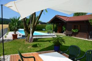 a patio with a table and chairs under a white umbrella at Haus Gruber in Attersee am Attersee