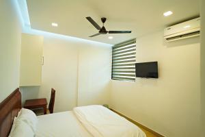 a bedroom with a bed and a ceiling fan at GH Grand Park in Angamaly