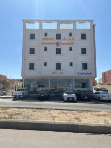 a large white building with cars parked in front of it at الغاف للشقق المخدومة in Sarat Abidah