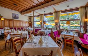 a restaurant with white tables and pink chairs at Hotel & Restaurant Mainaublick in Uhldingen-Mühlhofen
